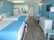 Comfortable hotel room with two beds, kitchenette, dining area, and light blue accent wall at 9980 Gulf Blvd # 408, Treasure Island, FL 33706