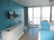 Bright bedroom with turquoise walls, stylish octopus-themed dresser, and sliding glass doors to a balcony at 9980 Gulf Blvd # 408, Treasure Island, FL 33706