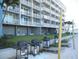 Multi-story building featuring outdoor grills on the beach and individual balconies with white railings at 9980 Gulf Blvd # 408, Treasure Island, FL 33706