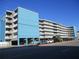 Condo building featuring a blue accent wall and tiered balconies, offering a coastal living experience at 9980 Gulf Blvd # 408, Treasure Island, FL 33706