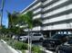 Exterior shot of a beachside building with parking and partial views of palm trees and ocean at 9980 Gulf Blvd # 408, Treasure Island, FL 33706