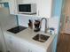 Modern kitchenette featuring white cabinets, quartz countertops, stainless steel sink, and modern appliances at 9980 Gulf Blvd # 408, Treasure Island, FL 33706