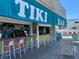 Vibrant tiki bar adjacent to a swimming pool, featuring colorful stools and shaded seating at 9980 Gulf Blvd # 408, Treasure Island, FL 33706