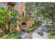 A condo building exterior has stairs, palm trees, and tropical foliage along a sidewalk at 100 4Th S Ave # 103, St Petersburg, FL 33701