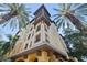 Stunning exterior of a yellow building with balconies framed by lush palm trees at 100 4Th S Ave # 103, St Petersburg, FL 33701