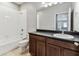Bathroom with a shower, a toilet, and vanity with dark wood cabinets at 11541 Tangle Branch Ln, Gibsonton, FL 33534