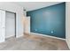 Carpeted bedroom with a blue accent wall, a closet, and a doorway to another room at 11541 Tangle Branch Ln, Gibsonton, FL 33534