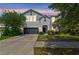 Charming two-story home featuring a well-manicured lawn and a two-car garage at dusk at 11541 Tangle Branch Ln, Gibsonton, FL 33534