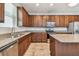 Kitchen features stainless steel appliances, granite counters, wood cabinets, and tile floors at 11541 Tangle Branch Ln, Gibsonton, FL 33534