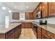 Elegant kitchen with granite countertops, dark wood cabinets, and stainless steel appliances at 11541 Tangle Branch Ln, Gibsonton, FL 33534