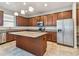 The kitchen boasts an island, dark cabinetry, stainless steel appliances, granite countertops and tile floors at 11541 Tangle Branch Ln, Gibsonton, FL 33534