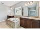 Main bathroom showcasing a bathtub, dual sinks, granite countertops, and ample natural light at 11541 Tangle Branch Ln, Gibsonton, FL 33534