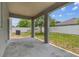 Backyard view from a covered patio with concrete flooring and supporting pillars at 11541 Tangle Branch Ln, Gibsonton, FL 33534