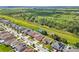A high aerial view displays neighborhood houses in a grid, some with solar panels, near green spaces and a railway at 11551 Brighton Knoll Loop, Riverview, FL 33579