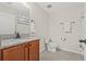 Bathroom featuring granite countertop, wood cabinets, and neutral tile flooring at 11551 Brighton Knoll Loop, Riverview, FL 33579