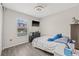 Cozy bedroom with wood floors, ceiling fan, window views, and playful dinosaur decor at 11551 Brighton Knoll Loop, Riverview, FL 33579