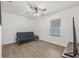 Simple bedroom featuring wood-look floors, neutral walls, a window, and a futon for versatile use at 11551 Brighton Knoll Loop, Riverview, FL 33579
