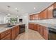 Modern kitchen with ample counter space, wood cabinetry, stainless steel appliances, and a view of the living area at 11551 Brighton Knoll Loop, Riverview, FL 33579