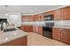 Well-equipped kitchen with granite countertops, wood cabinets, stainless steel appliances, and tile flooring at 11551 Brighton Knoll Loop, Riverview, FL 33579