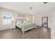 Cozy main bedroom features wood-look floors, ceiling fan, and ample natural light at 11551 Brighton Knoll Loop, Riverview, FL 33579