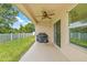 Outdoor patio space with a ceiling fan, grill, and view of the green backyard, ideal for relaxing at 11551 Brighton Knoll Loop, Riverview, FL 33579
