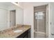 Well-lit bathroom features a granite countertop vanity, a large mirror, and tiled shower at 11918 Winterset Cove Dr, Riverview, FL 33579
