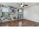 Cozy bedroom with hardwood floors, ceiling fan, and unique geometric accent wall at 11918 Winterset Cove Dr, Riverview, FL 33579
