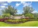 Beautifully landscaped community entrance sign with stone pillars, manicured gardens, and mature trees at 11918 Winterset Cove Dr, Riverview, FL 33579