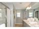 Well-lit bathroom with double vanity, sleek finishes, and a glass-enclosed shower at 12474 Gust Ct, Hudson, FL 34669
