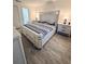 Bright bedroom showcasing a king bed, wood-look tile flooring, and modern white furniture at 13186 Thrush St, Spring Hill, FL 34609