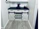 Functional coffee bar area featuring a wine rack, white cabinets, a black countertop, and sliding barn doors at 13186 Thrush St, Spring Hill, FL 34609