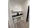 Neat coffee bar offers white cabinets, a black countertop, wine glass rack, and sliding barn doors at 13186 Thrush St, Spring Hill, FL 34609
