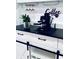 Stylish coffee bar features white cabinetry, a black countertop, wine glass rack, and modern espresso machine at 13186 Thrush St, Spring Hill, FL 34609
