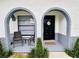 Close up of arched entry with seating area and decorative door, welcome mat and shrubbery at 13186 Thrush St, Spring Hill, FL 34609