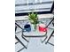 A cozy front porch setting with a side table, coffee cups, and a view to the front window at 13186 Thrush St, Spring Hill, FL 34609