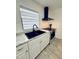 Bright kitchen boasts white cabinets, a black sink, marble countertops and stainless steel appliances at 13186 Thrush St, Spring Hill, FL 34609