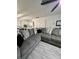 Bright living room featuring a large sectional sofa with decorative pillows and wood-look tile flooring at 13186 Thrush St, Spring Hill, FL 34609