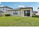 Exterior view of a home with a covered patio and lush green lawn at 13515 Palmera Vista Dr, Riverview, FL 33579