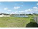 Green backyard view overlooking a tranquil pond surrounded by suburban homes at 13515 Palmera Vista Dr, Riverview, FL 33579