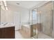 Well-lit bathroom featuring double sinks, a soaking tub, and a separate glass-enclosed shower at 13515 Palmera Vista Dr, Riverview, FL 33579