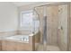 Bright bathroom featuring a soaking tub and a glass-enclosed shower for a spa-like experience at 13515 Palmera Vista Dr, Riverview, FL 33579