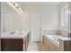 Bathroom with double sinks, soaking tub, and stylish lighting, creating a serene and functional space at 13515 Palmera Vista Dr, Riverview, FL 33579