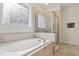 Bright bathroom featuring a soaking tub and a glass-enclosed shower for a spa-like experience at 13515 Palmera Vista Dr, Riverview, FL 33579