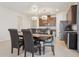 Well-lit dining area showcasing modern chandeliers, dark wood cabinets, and stainless steel appliances at 13515 Palmera Vista Dr, Riverview, FL 33579