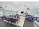Community clubhouse with tables, chairs, kitchen and mounted television at 13710 Mission Oaks Blvd # 2A, Seminole, FL 33776