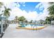 Large community pool surrounded by lounge chairs and lush palm trees, offering a relaxing outdoor retreat at 13710 Mission Oaks Blvd # 2A, Seminole, FL 33776
