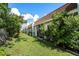 Backyard view of condo building with green grass and manicured landscaping at 13710 Mission Oaks Blvd # 2A, Seminole, FL 33776
