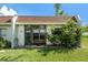 Exterior view of condo building with well maintained landscaping and large glass windows at 13710 Mission Oaks Blvd # 2A, Seminole, FL 33776