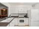 Bright kitchen featuring white cabinetry, standard appliances, and ample counter space at 13710 Mission Oaks Blvd # 2A, Seminole, FL 33776