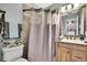Cozy bathroom with decorative shower curtain, vanity, and tiled floors at 13814 Lavender Ave, Hudson, FL 34667